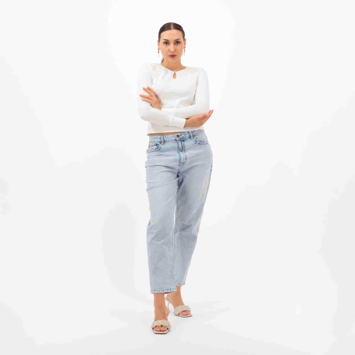 A luxury casual outfit, featuring a white keyhole top and light-wash jeans.