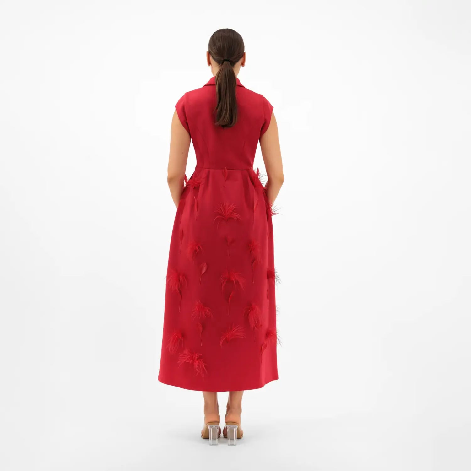 Woman wearing a red dress with floral patterns on a white background