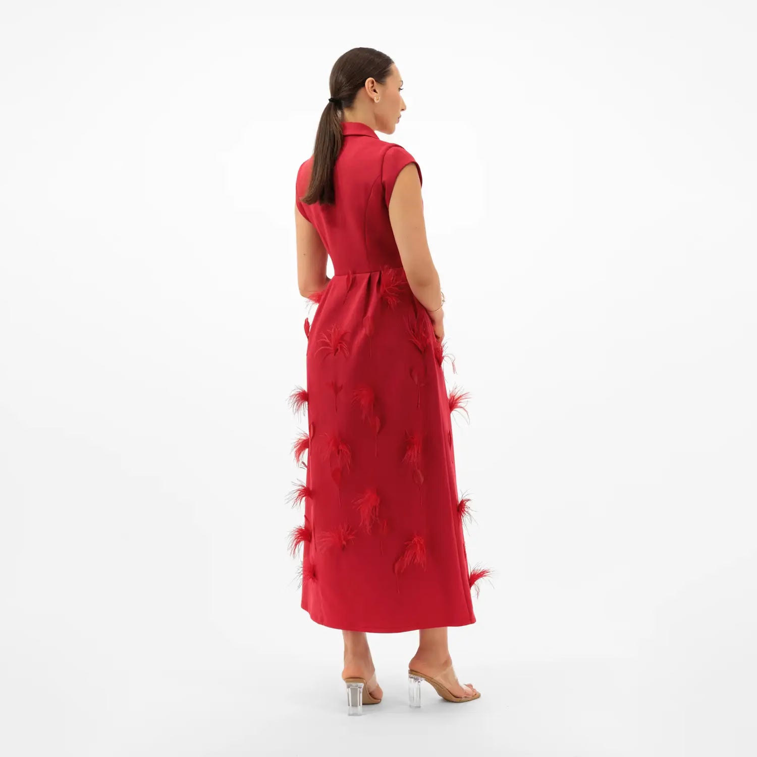 Woman wearing a red dress with floral details on a white background