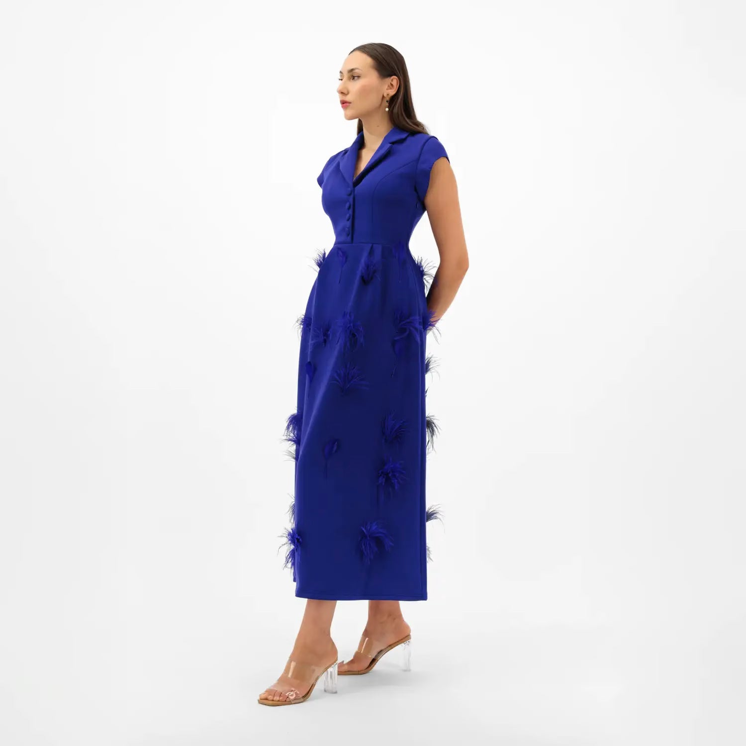 Woman wearing a blue dress with floral details on a white background